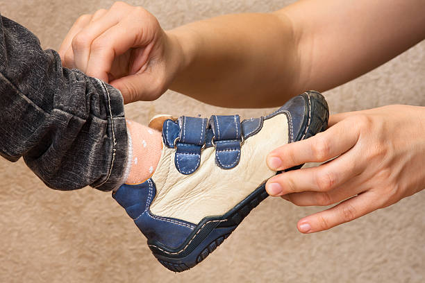 istock hands of mother put on shoes child 526282986
