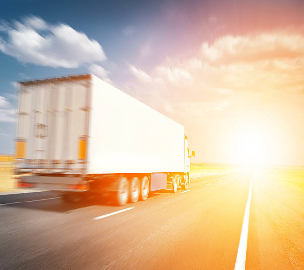 istock semitruck driving to sunset 526283853