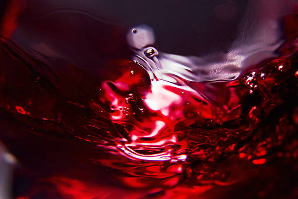 Red wine Red wine on a black background , abstract splashing. merlot grape photos stock pictures, royalty-free photos & images