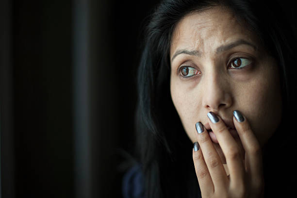 Zaniepokojony azjatyckie Młoda kobieta umieszczenie jej rękę na ustach. – zdjęcie