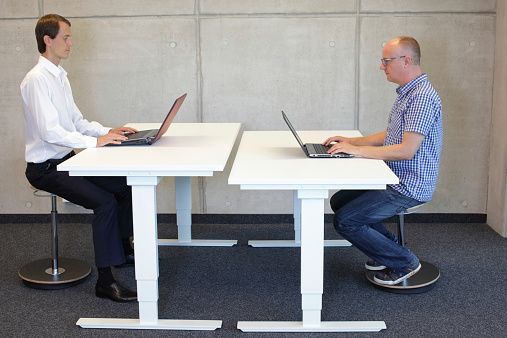 coworkers in correct sitting posture on balance stools