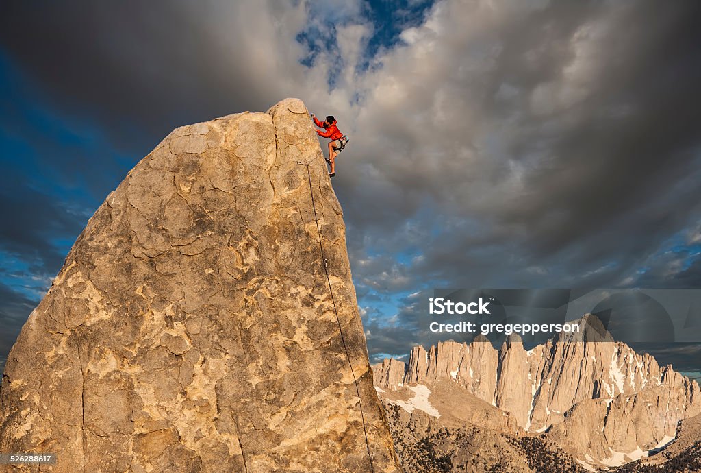 Climber on the edge. Climber struggles to the summit of a challenging cliff. Achievement Stock Photo