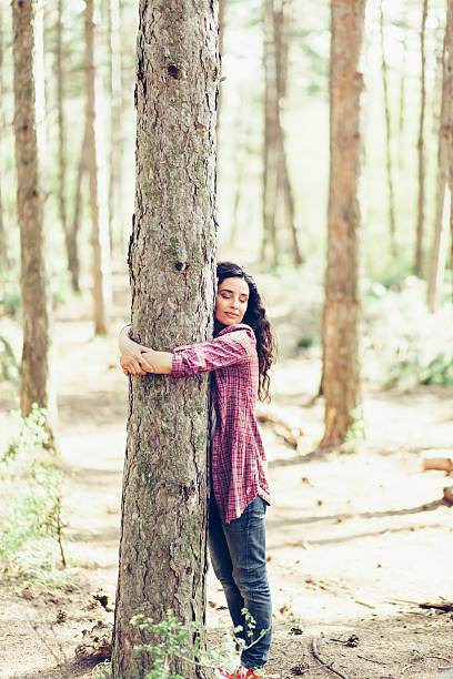 istock Young woman hugging a tree in the forest 526289372