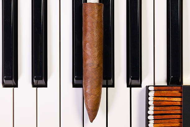 istock Piano keyboard and luxury cigar 526292264