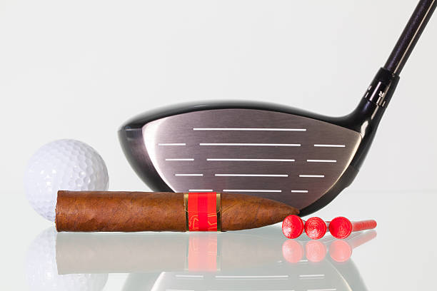 istock Golf driver and different cigars on a glass desk 526292344