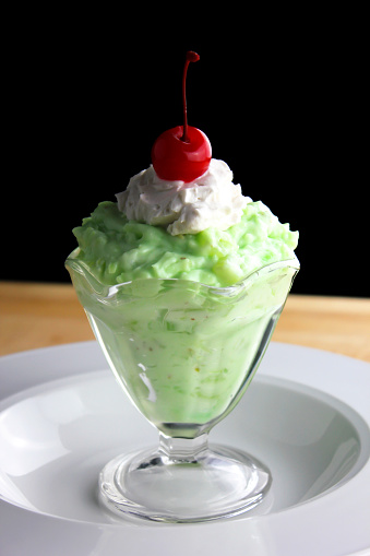 A homemade Watergate salad in a glass dessert dish.  Also known as Pistachio Delight.