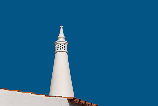 Portugese rooftop chimney Traditional Portugese rooftop chimney against a clear blue sky. alte algarve stock pictures, royalty-free photos & images