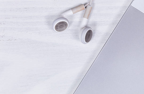 istock Cell phone and earpieces on clean white desktop background 526297750