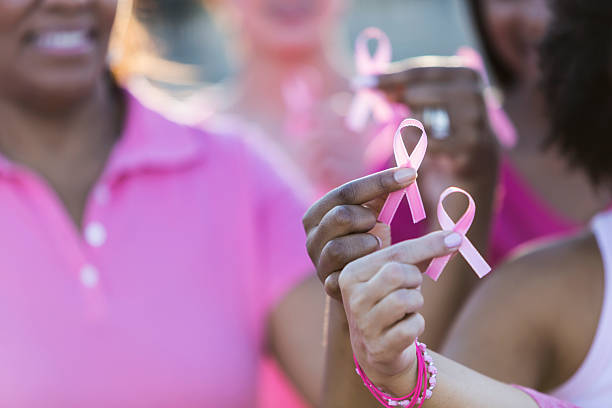 istock Multiracial hands holding breast cancer awareness ribbon 526298336