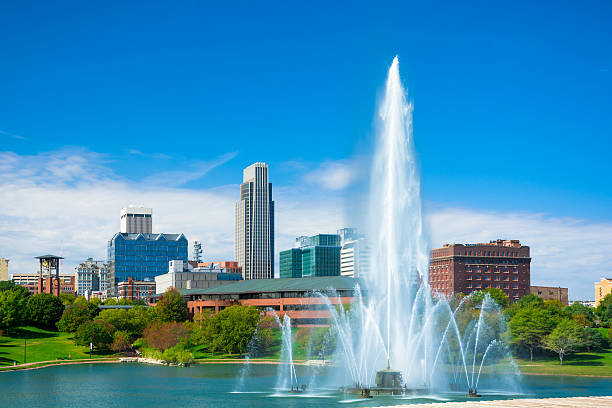 Omaha skyline with fountain and lake Downtown Omaha skyline in the background with a huge and elaborate fountain and a lake in the foreground (part of the Heartland of America park.) nebraska stock pictures, royalty-free photos & images