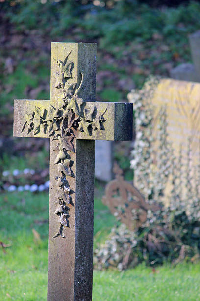 istock Image of old cross-shaped granite RIP gravestone, church cemetery graveyard 526308805