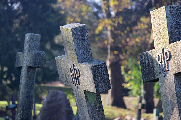 istock Old cross-shaped granite RIP gravestones / crosses, church cemetery graveyard falling-over 526308809