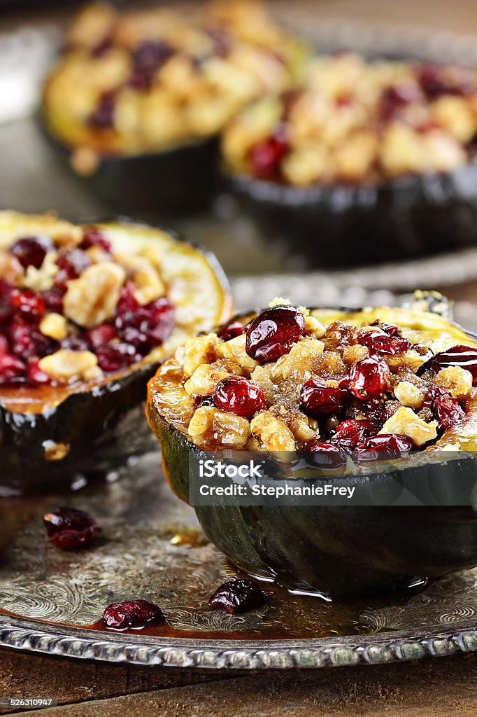 Delicious Stuffed Acorn Squash Acorn squash stuffed and baked with butter, brown sugar, walnuts and cranberries, ready for holiday dinners. Extreme shallow depth of field with beautiful bokeh. FoodLove2014 Stuffed Stock Photo