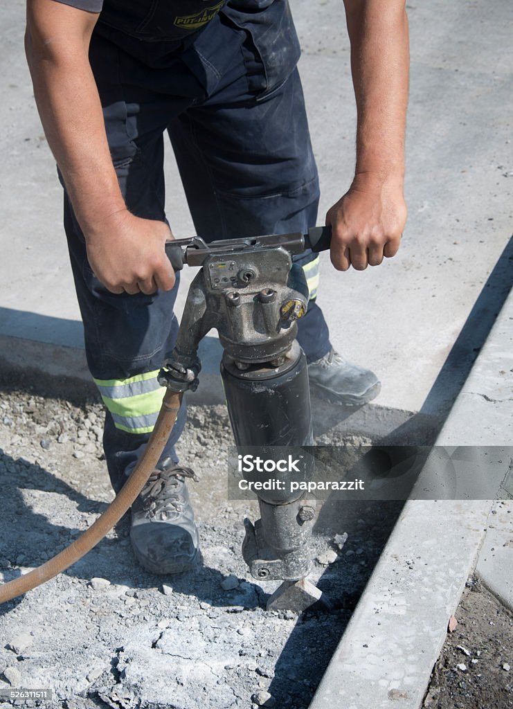 Operating A Jackhammer A man operating A Jackhammer on a street reconstruction Adult Stock Photo