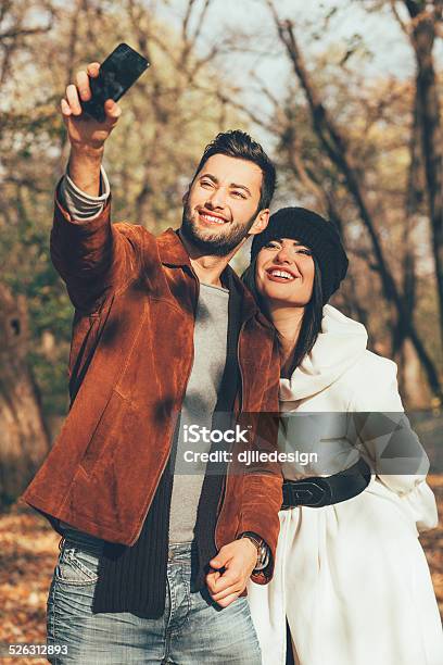 Young Couple Taking Selfie In The Park Stock Photo - Download Image Now - Adult, Adults Only, Autumn