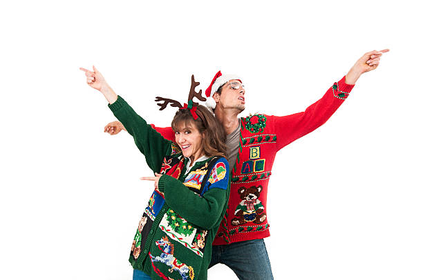 Holiday dancing A young couple in ugly sweaters dancing. Horizontal image isolated on white. nerd sweater stock pictures, royalty-free photos & images