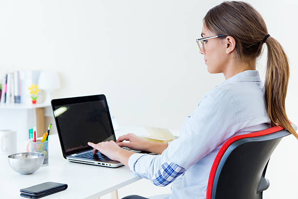 istock Pretty young woman using her laptop in the office. 526313639
