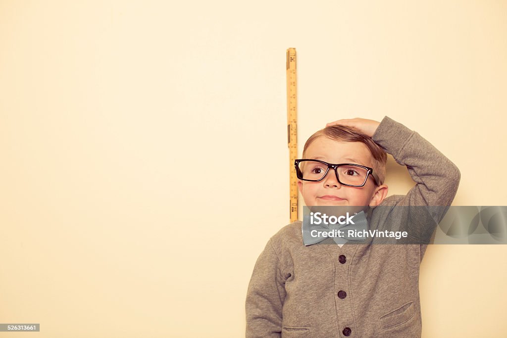 Short Male Nerd A young child wants to be taller. Big things with becoming big.  Measuring Stock Photo