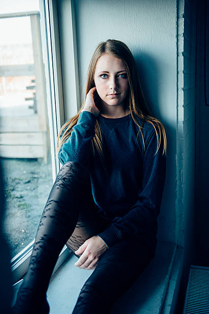 istock Woman sitting on a windows shelf 526313717