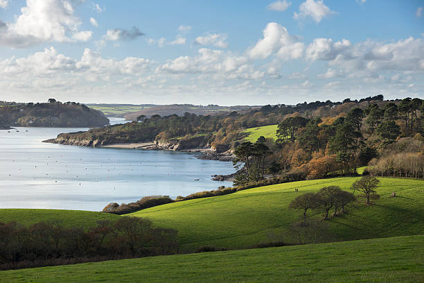 Helford River The Helford river in Cornwall on a beautiful Winter afternoon. A couple can be seen walking the footpath. Taken near Mawnan Smith. cornwall england stock pictures, royalty-free photos & images