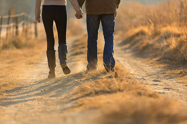 istock young couple holding hands walking on autumn path 526321129