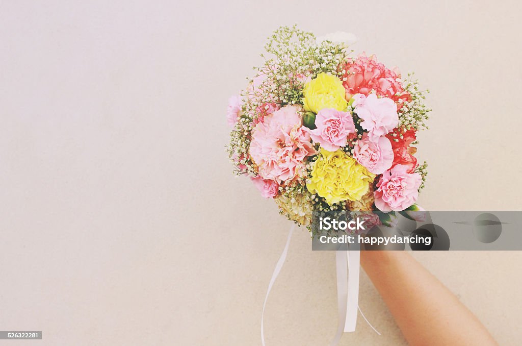 Bouquet of flower in hand and white wall Bouquet of flower in hand and white wall with retro filter effect Adult Stock Photo