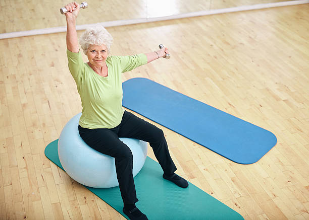 istock Active senior woman at gym exercising with weights 526322433