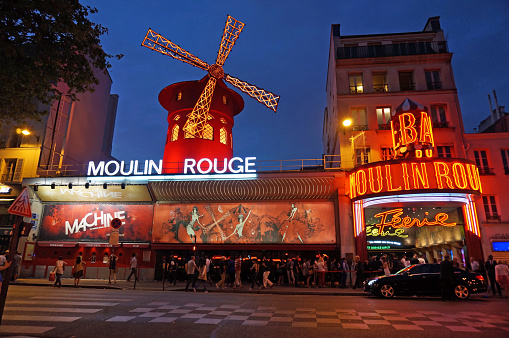 Paris, France-September 7, 2014:  These people are waiting in line to see a cabaret show at the Moulin Rouge Cabaret in Paris France.  This famous landmark is located in the red light district on the outskirts of Paris.