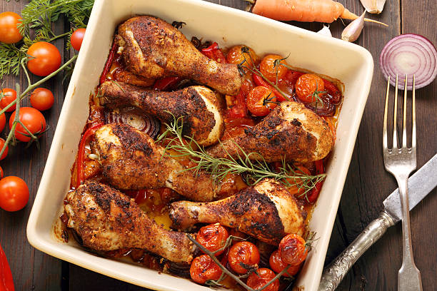 istock Roasted chicken drumsticks with vegetables in a pan 526350247