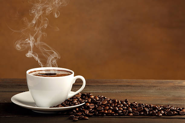 istock Black coffee in white cup with smoke and coffee beans 526351487