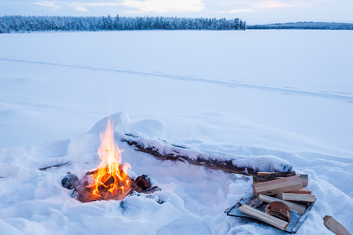 Campfire burning in winter landscape