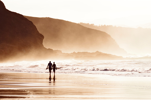 couple walking on the beach with fog