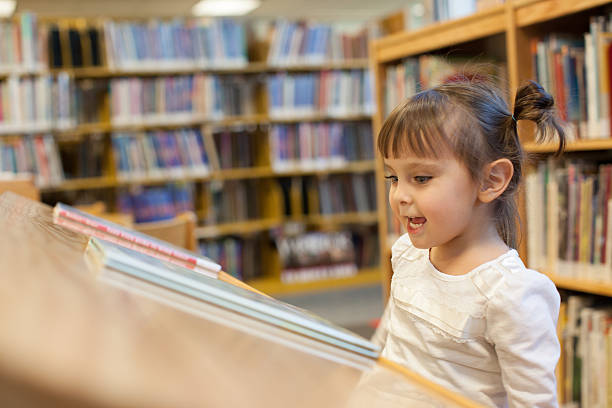 istock Preschooler Child is Reading a Book At the Library 526354553