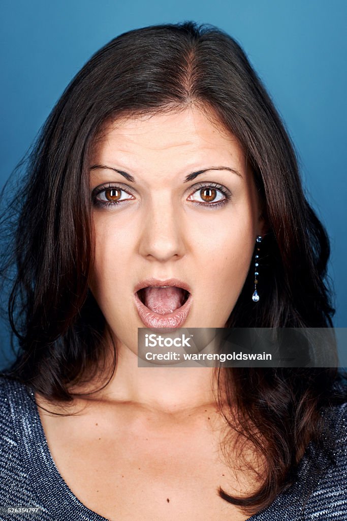 silly face woman funny face portrait of woman on blue background Adult Stock Photo