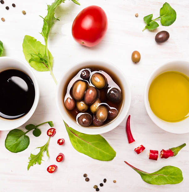 condimentos para las ensaladas en blanco y tazones con especias, aceitunas y hierbas - vinegar salad dressing balsamic vinegar olive oil fotografías e imágenes de stock