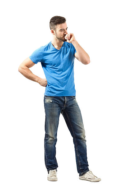 Young man in blue t-shirt thinking looking down stock photo