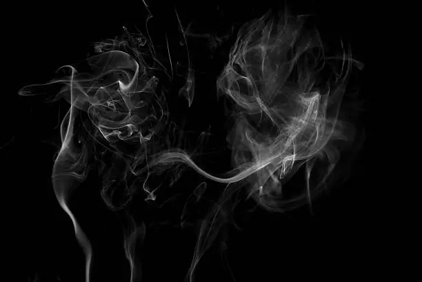 Smoke swirling around against a black backgroundSmoke swirling around against a black background