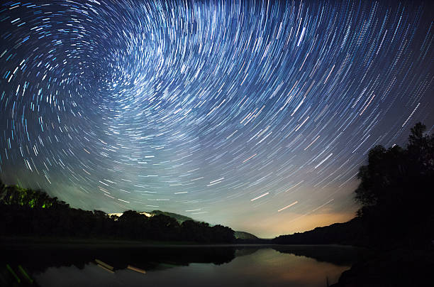 istock beautiful night sky, Milky Way, spiral star trails and  trees 526373221