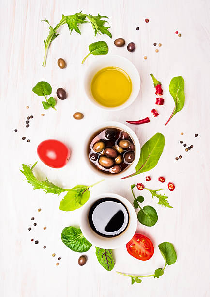 ensalada preparación con protectores, aceitunas, wild hebs, aceite y tomates - vinegar salad dressing balsamic vinegar olive oil fotografías e imágenes de stock