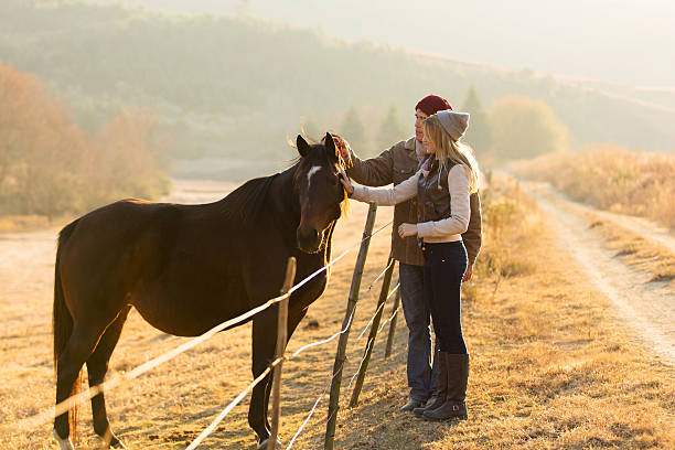 istock couple petting horse 526391847