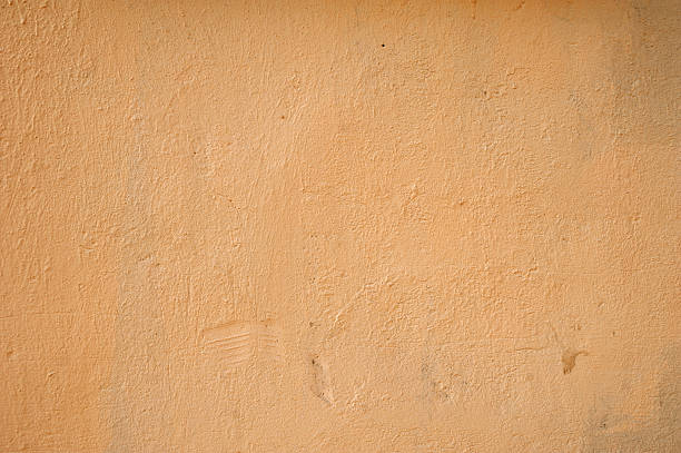 istock Texture of old wall covered with yellow stucco 526392491