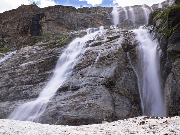 istock Panorama of a large stepped waterfall with snow 526393831