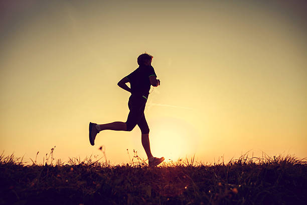 istock Running man silhouette in sunset time 526421181
