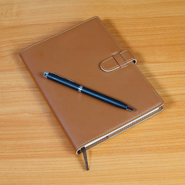 istock brown notebook and pen over wooden background 526421439