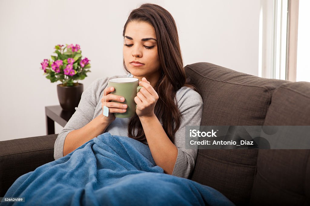 Enjoying tea on a cold day Beautiful girl enjoying a cup of tea on a cold day at home 20-29 Years Stock Photo