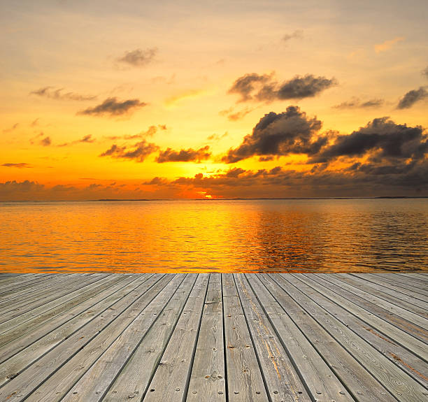 istock Wooden platform beside tropical sea with sunset 526425695