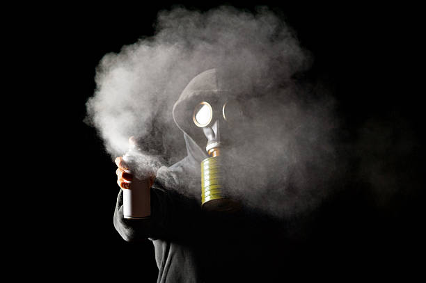 istock Hooded Man Wearing Gas Mask Spraying With Spray Can 526428357