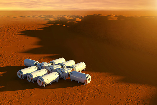Fictional illustration of a space base outpost on the red surface of planet Mars: a group of modules are connected by hubs forming an extraterrestrial colony for starting Mars exploration. 