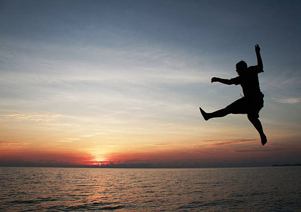 istock Jumping Sunset Sunrise Beach and Sea 526443085