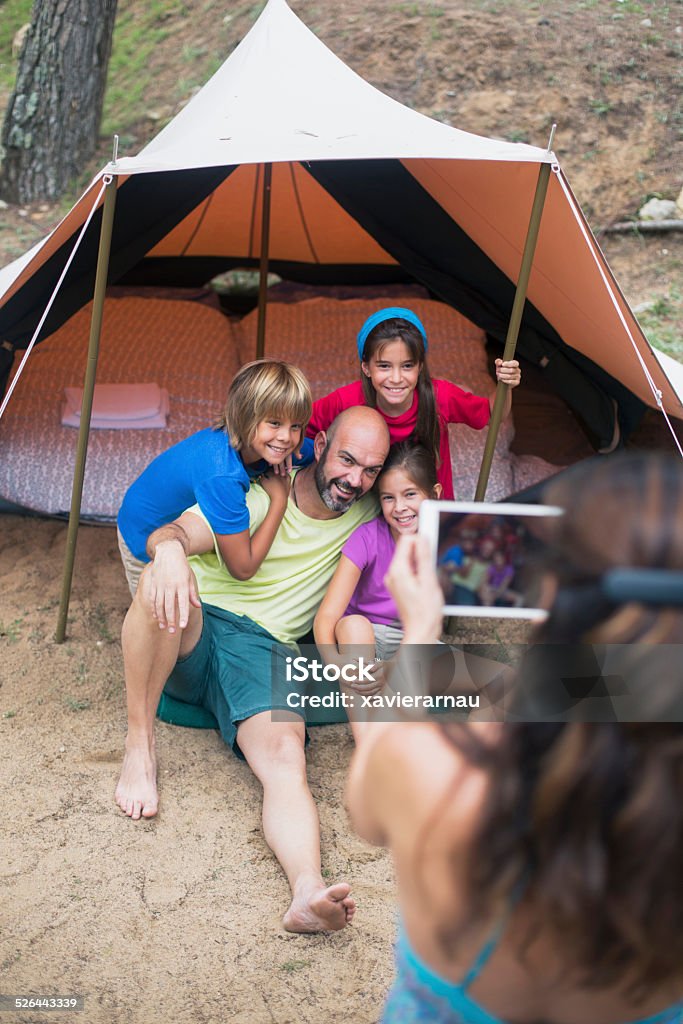 Family portrait in the camping Mother taking a picture of her family on holidays. Tent Stock Photo